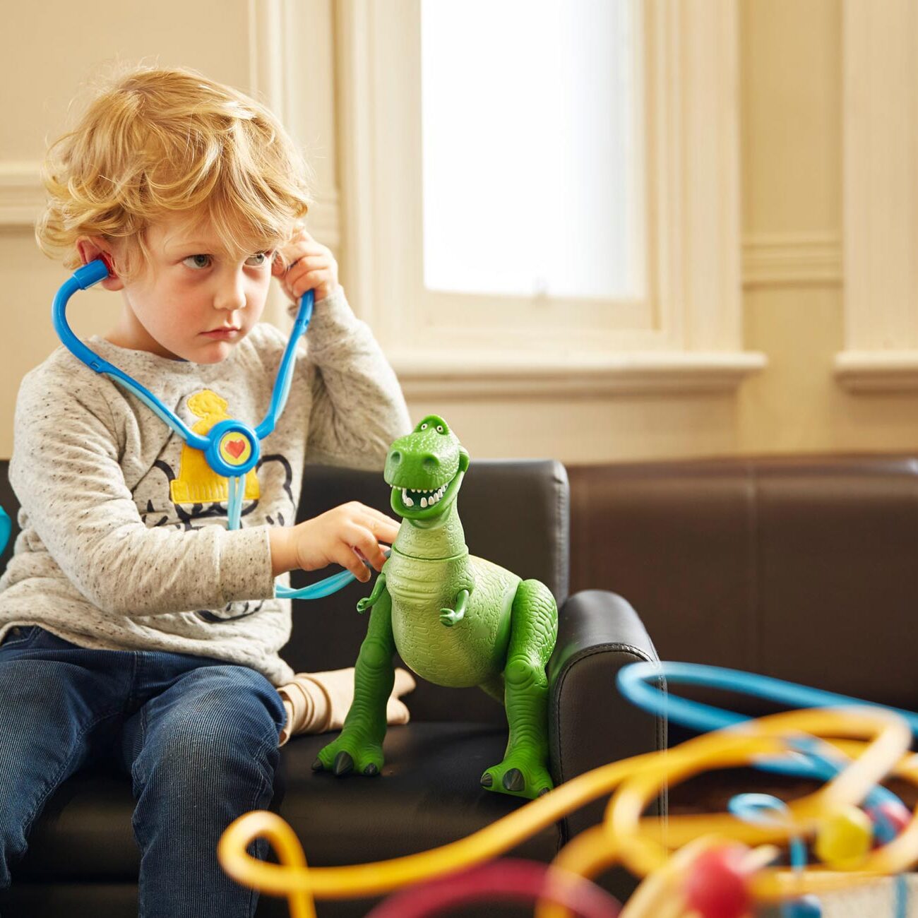 Child using stethoscope on plastic T-Rex